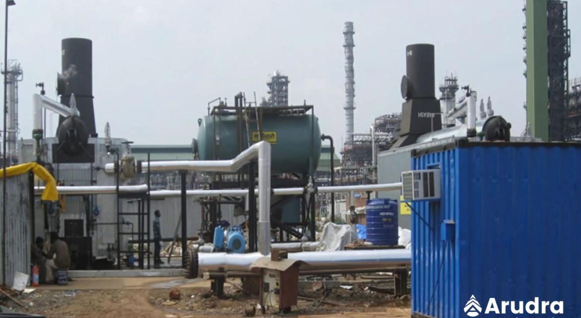 A blue container with pipes in front of a blue building, showcasing industrial architecture.