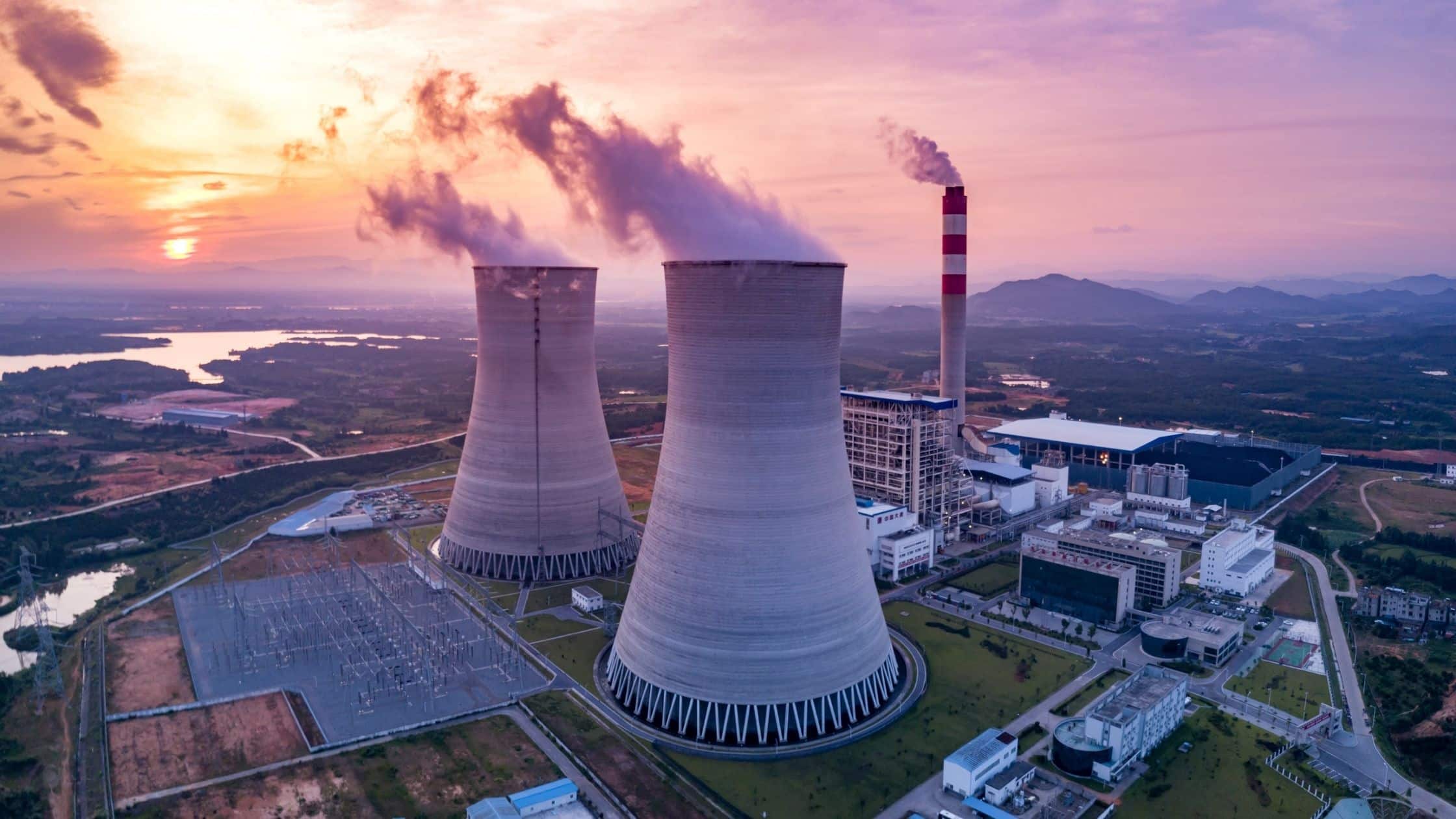 Aerial view of thermal power plant cooling towers releasing steam